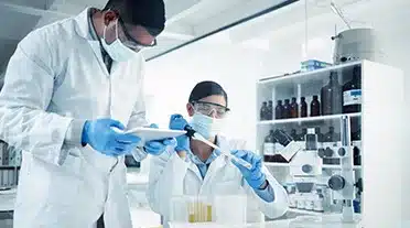 Deux jeunes alternants en laboratoire travaillant pendant leurs études de biotechnologies