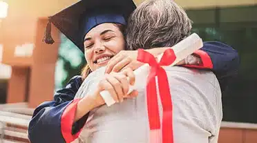 Etudiante serrant son père dans les bras le jour de son diplôme