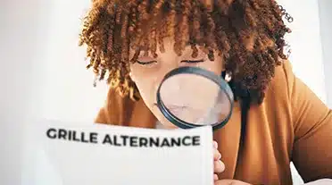 Jeune alternante étudiant à la loupe la grille d'alternance 2025