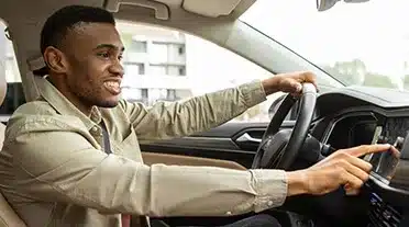 Un jeune démarrant sa voiture grâce à l'aide au permis pour les apprentis