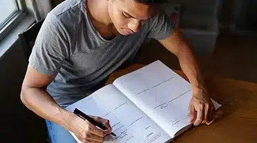 Jeune étudiant qui coche sa liste des choses à faire pour trouver une alternance