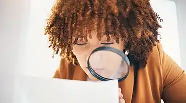 Jeune fille cherchant une offre d'alternance à la loupe