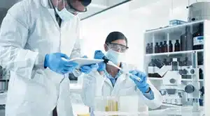 Jeune alternance avec son maitre d'apprentissage dans un laboratoire de chimie et biotechnologie