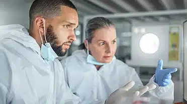 Jeune alternant avec son maitre d'apprentissage dans un laboratoire de chimie