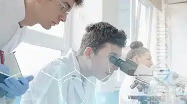 Jeune apprentis dans les sciences au laboratoire regardant dans un microscope