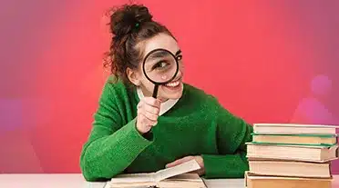 Jeune étudiante scrutant à la loupe toute les informations sur la durée d'un contrat d'apprentissage