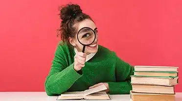 Jeune étudiante scrutant à la loupe les bons conseils pour préparer son entretien d'embauche en alternance