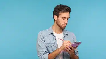 Jeune alternant qui note tous les conseils sur l'habillement pour un entretien d'embauche