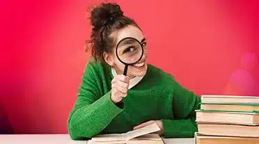 étudiante regardant à la loupe les ressources disponibles pour trouver son employeur en alternance