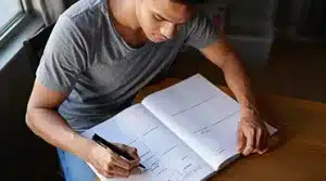 Jeune alternant à la recherche d'un contrat sur paris notant ses rdv sur son agenda