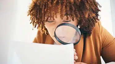 Etudiante scrutant à la loupe les détails sur les congés en alternance