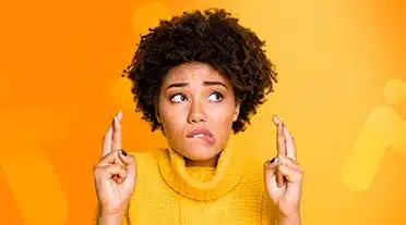 étudiante croisant les doigts suite à son entretien téléphonique, elle va maintenir le contact