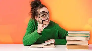 étudiante observant à la loupe les conditions pour bénéficier des aides au logements