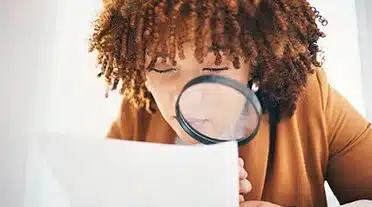 étudiante observant à la loupe la rémunération de l'alternant