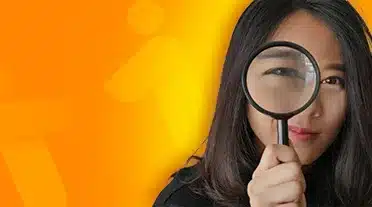 étudiante observant à la loupe les conditions d'éligibilité au contrat d'apprentissage