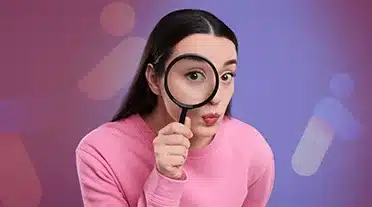 étudiante observant à la loupe les questions fréquentes sur la paie en alternance